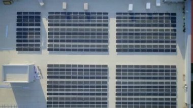 Elektrik üreten fabrikanın çatısındaki güneş panellerinin insansız hava aracı görüntüsü. Yeşil enerji