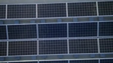 Elektrik üreten fabrikanın çatısındaki güneş panellerinin insansız hava aracı görüntüsü. Yeşil enerji