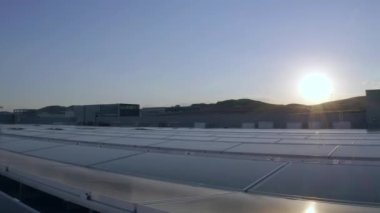 Elektrik üreten fabrikanın çatısındaki güneş panellerinin insansız hava aracı görüntüsü. Yeşil enerji