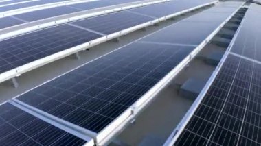Elektrik üreten fabrikanın çatısındaki güneş panellerinin insansız hava aracı görüntüsü. Yeşil enerji