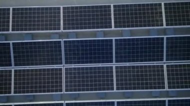 Elektrik üreten fabrikanın çatısındaki güneş panellerinin insansız hava aracı görüntüsü. Yeşil enerji