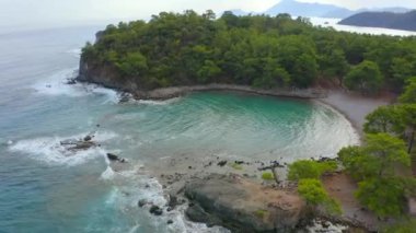 Akdeniz ormanı ve okyanus denizinin hava aracı. Bir sürü yeşil ve mavi gökyüzü görebileceğiniz bir tatil ziyareti. Nehir denize dökülüyor ormandan ve antik bir şehrin kalıntılarından.