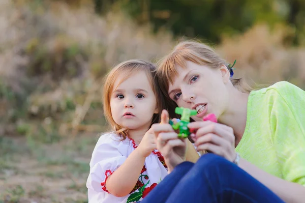 Filha e mãe estão brincando juntos ao ar livre — Fotografia de Stock