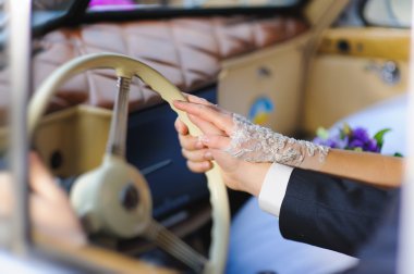 Kadın, erkek retro arabada direksiyon simidi üzerinde el