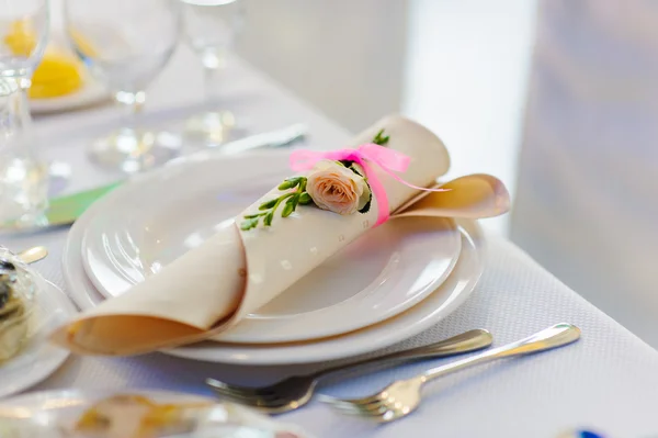 Tovagliolo con fiore di rosa su un piatto — Foto Stock
