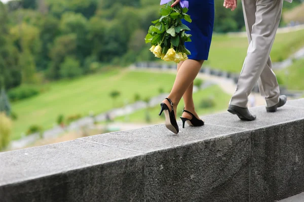 Jovem e mulher caminhando sobre uma parede de parapeito — Fotografia de Stock