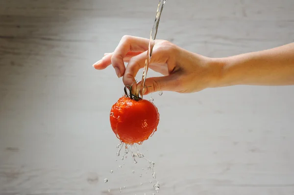 La mujer lava un tomate — Foto de Stock