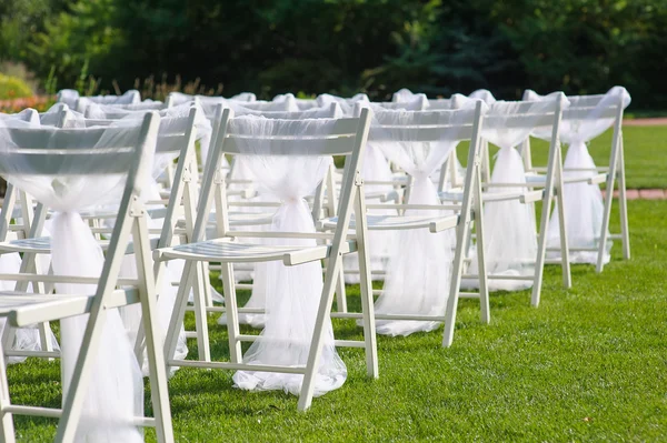 White decorated chairs on a green lawn