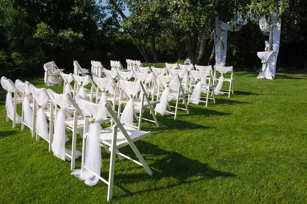 White decorated chairs on a green lawn — Stock Photo, Image