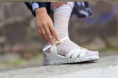 küçük kız onu sandalet koyarak