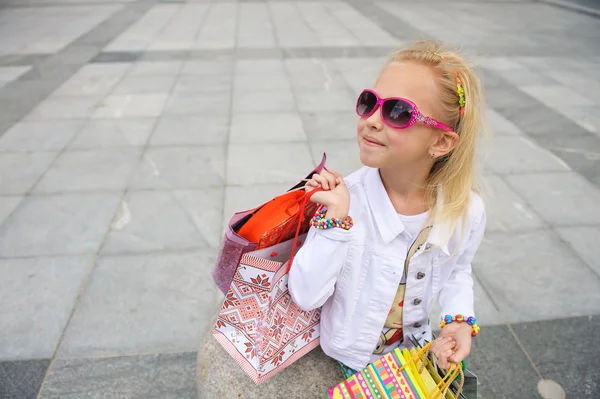 Young little girl with full shopping bags. — Stock Photo, Image