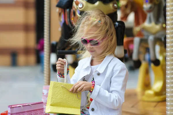 Child with shopping bags reviewing purchases — Stock Photo, Image