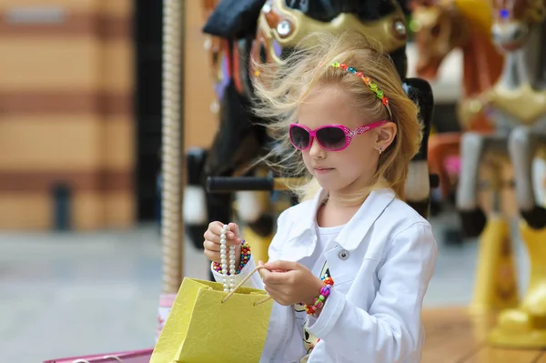 Child On Carousel with full shopping bags. — Stock Photo, Image