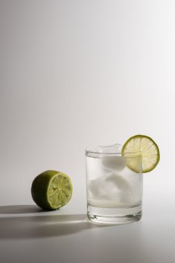 Beyaz arka plan üzerinde dilim limonlu limonata.