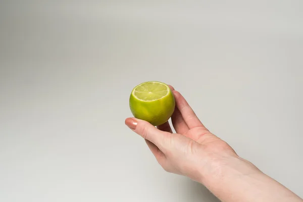 Green lime in a Female hand — Stock Photo, Image