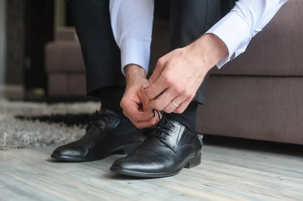 Man ties his shoes.