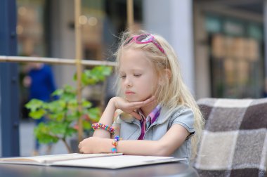 Güzel çocuk menüsü kafede okuma