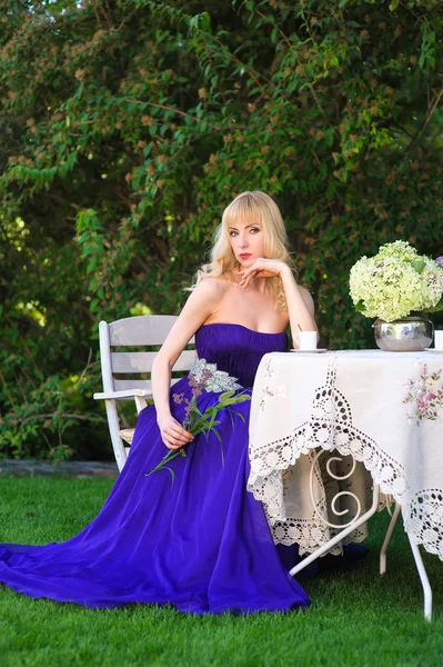 Frau an einem Tisch im Garten — Stockfoto