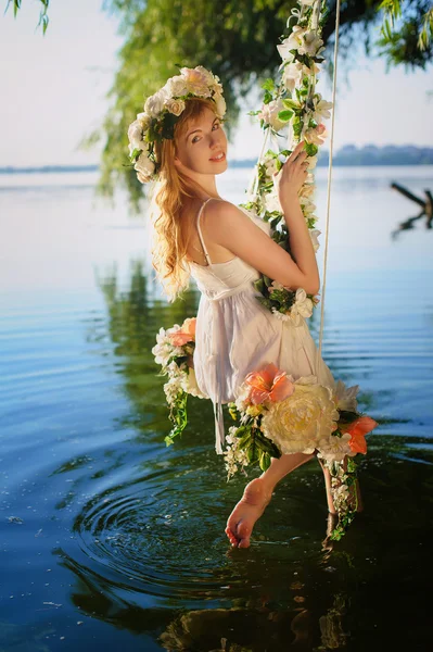 Mädchen auf Schaukel über Fluss — Stockfoto