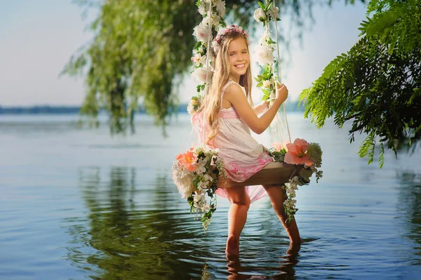 Mädchen auf Schaukel über Fluss — Stockfoto