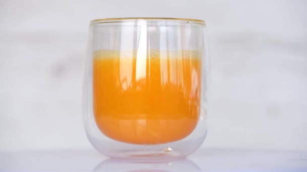 Girando vidrio transparente de jugo fresco de naranja — Vídeos de Stock