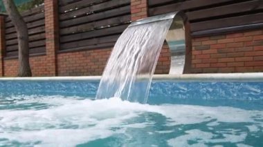 Yüzme havuzu şelalesi temiz su döker.