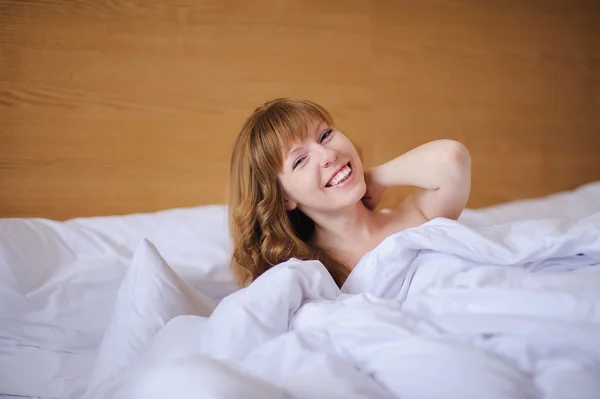 Menina sorrindo enquanto deitado na cama — Fotografia de Stock