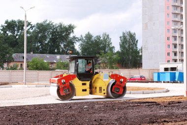Büyük asfalt Kompaktör inşaat alanında yaz gün içinde çalışıyor.