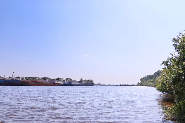 Fluss mit Frachtschiffen und Ufer überwucherten Büschen an Sommertagen — Stockfoto