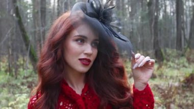 Siyah şapka teşkil sonbahar ormandaki oldukça gülümseyen kız