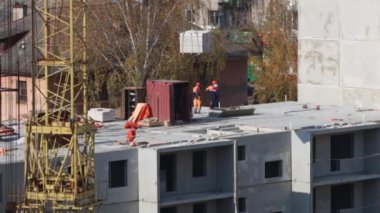 Vinç ağır yük asansörleri ve insanların inşaatta çalışma