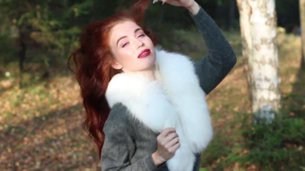 Pretty girl with white fur poses in sunny autumn forest — Stock Video