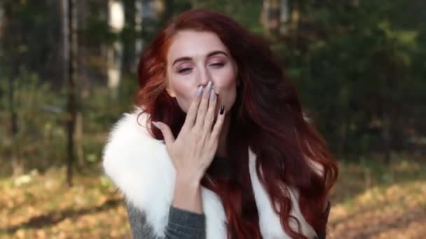 Mooi meisje met witte vacht stuurt ir kus in bos — Stockvideo