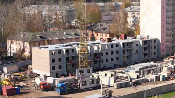 Кран разгружает бетонные панели из грузовика на строительной площадке — стоковое видео