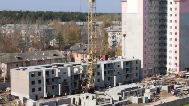 Guindaste em movimento no canteiro de obras e parte do edifício do painel de concreto — Vídeo de Stock