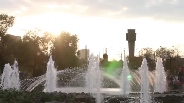 Фонтан с множеством всплесков и солнца в осеннем городе — стоковое видео