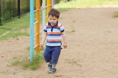 Küçük yakışıklı çocuk, çocuk oyun alanı kum üzerinde şort 
