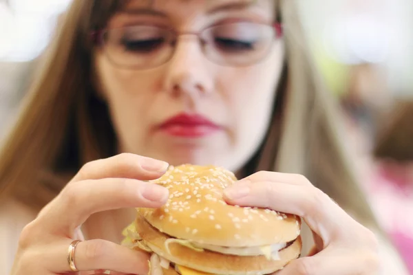 Donna si prepara per mangiare hamburger in caffè, concentrarsi su hamburger — Foto Stock