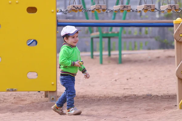 Przystojny chłopczyk bawi Samochodzik na plac zabaw dla dzieci — Zdjęcie stockowe