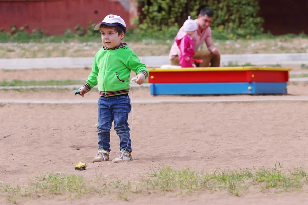 Щасливий красивий маленький хлопчик грає з іграшковою машиною — стокове фото