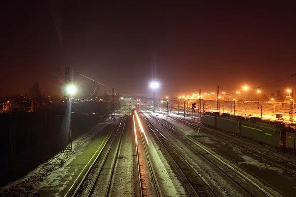 Goederentreinen met rijtuigen verplaatsen op spoor bij besneeuwde winter n — Stockfoto
