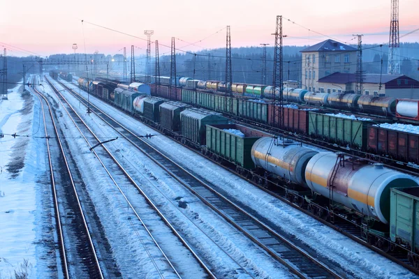 Tren de carga con tanques se mueve en los ferrocarriles en invierno nevado eveni — Foto de Stock