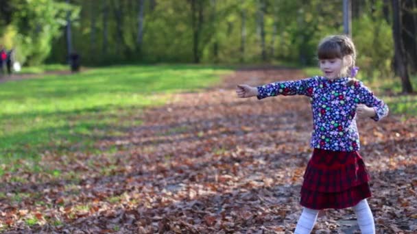 Schattig klein meisje speelt als archer in zonnige herfst park — Stockvideo