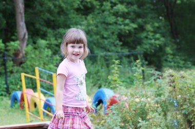 Güzel şirin küçük kız oyun arka plan üzerinde ayakta 