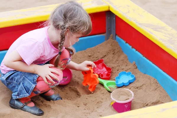 Mooi schattig klein meisje spelen in zandbak op warme zonnige dag — Stockfoto