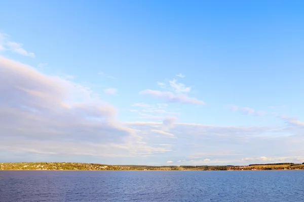 View of river and shore with settlements in distance on hot sunn — Stock Photo, Image