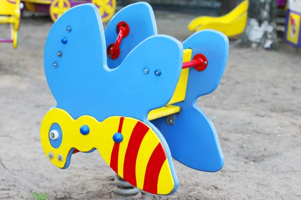 Colored rocking in form of bee on children playground at summer — Stock Photo, Image