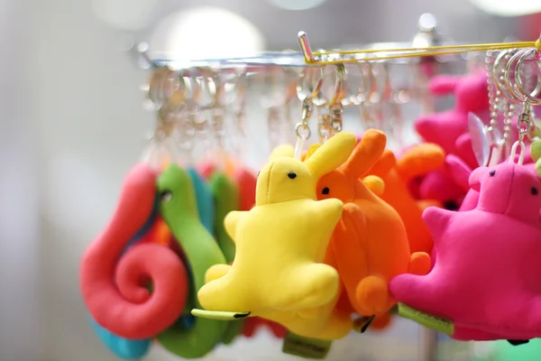 Small soft multicolored bunnies and snakes keychains hang in sho — Stock Photo, Image
