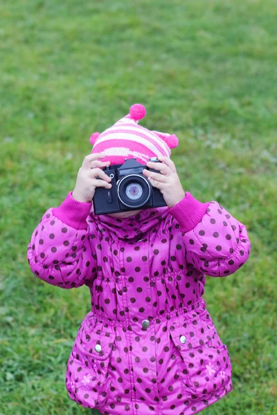 Little girl in pink photographs by camera rarity outdoors at aut — Stock Photo, Image