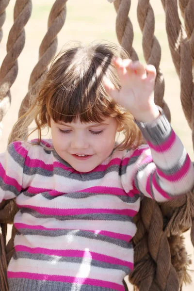 Pretty happy young beautiful girl in striped sweater slips on ro — Stock Photo, Image